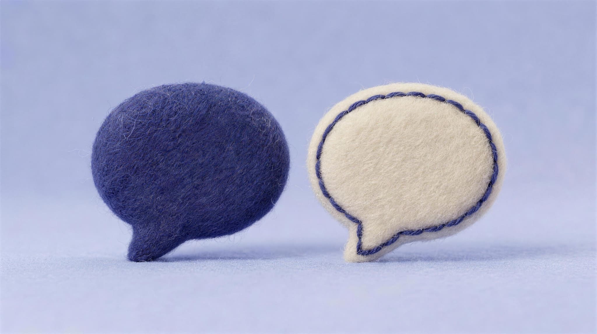 Two felt chat bubbles facing each other, a conversation ready
