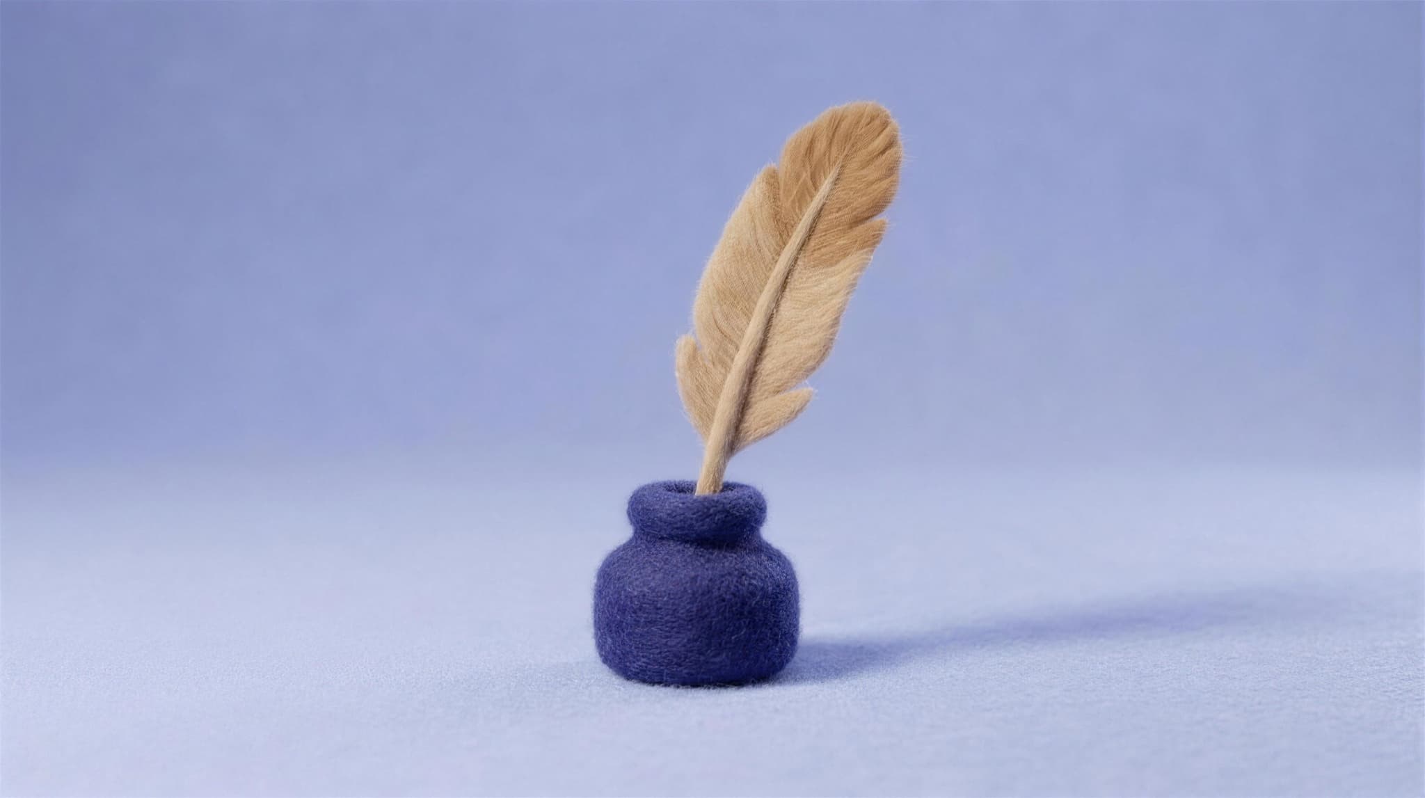 A tan felt quill standing in an indigo felt inkwell