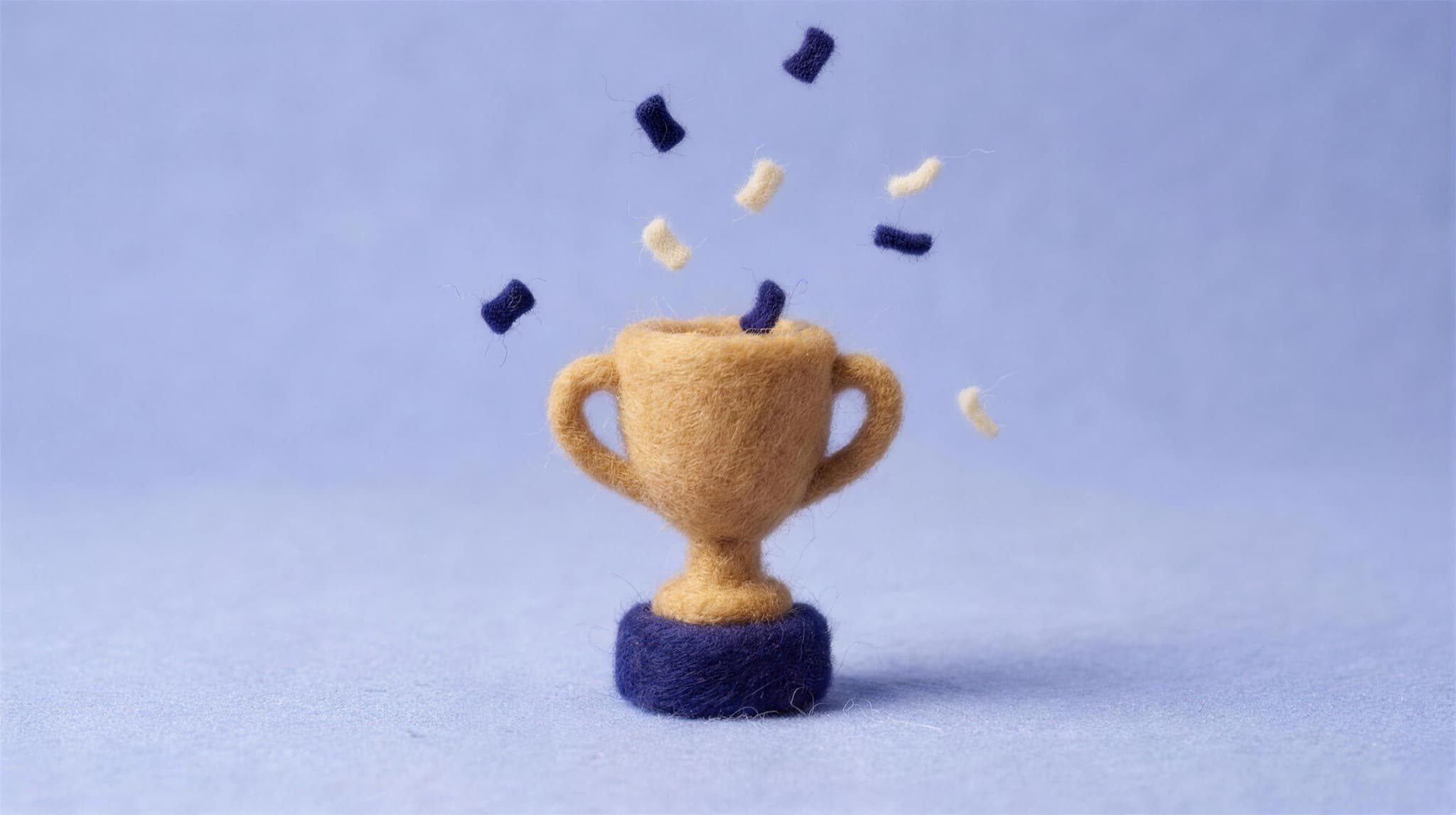 A felted trophy with confetti falling around it
